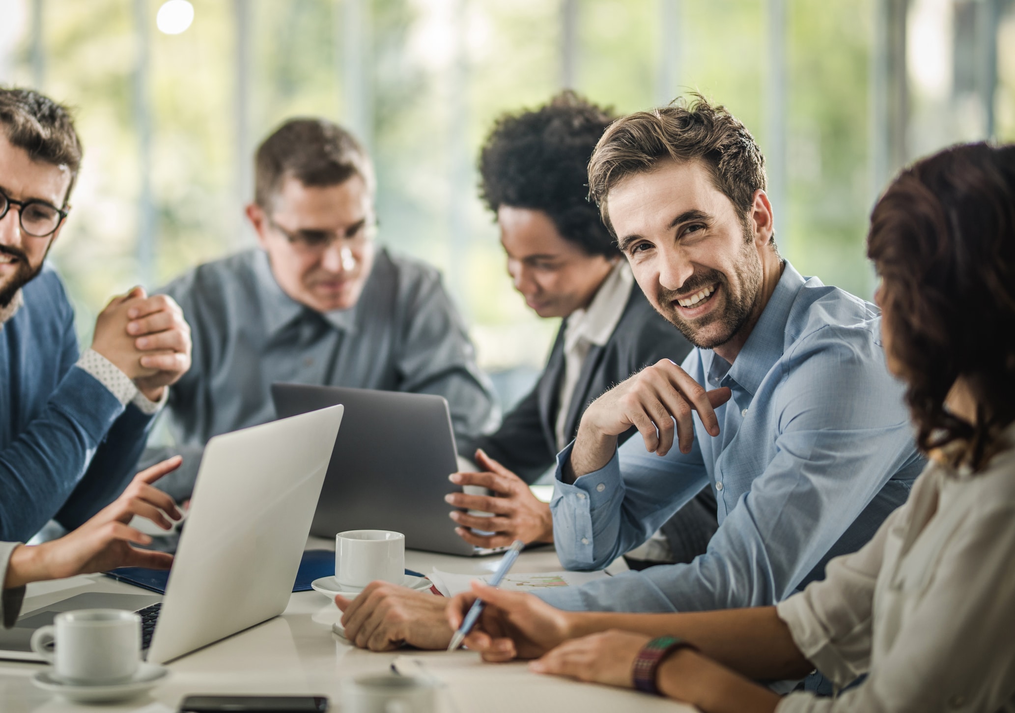 Happy businessman on a meeting with his colleagues in the office.